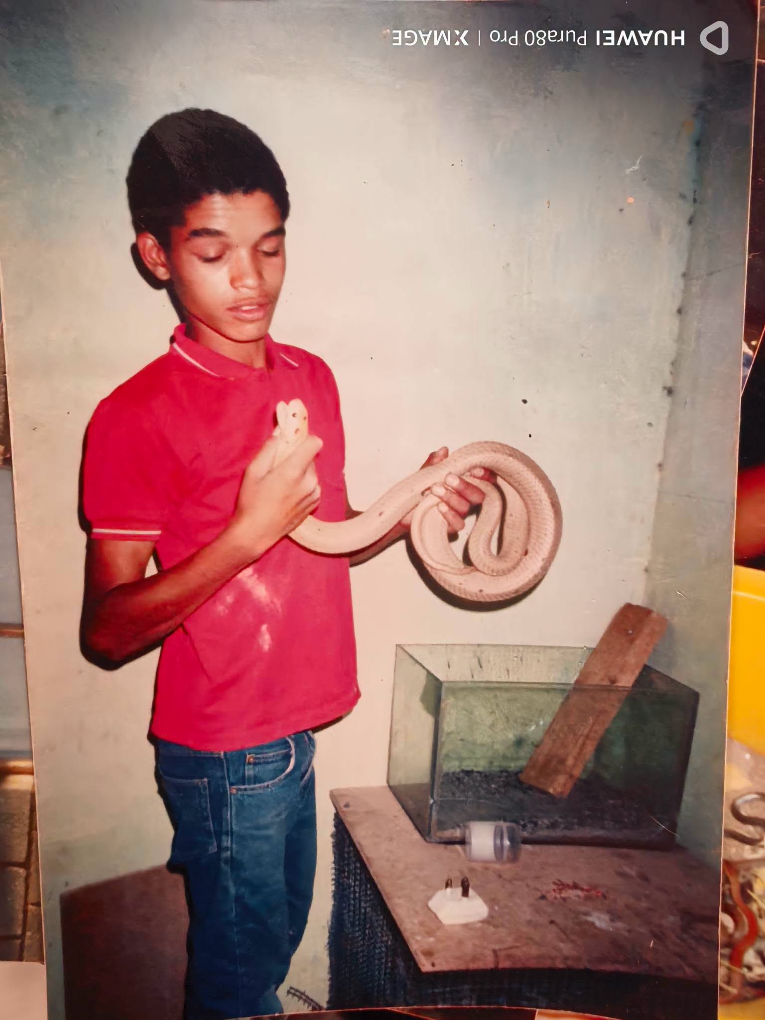 A young Buru holding a snake